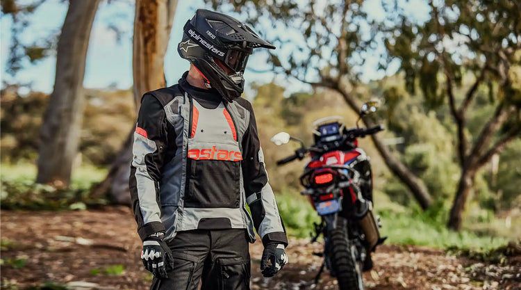 Equipo de motocicleta de aventura que incluye un casco, chaqueta, pantalones y guantes.
