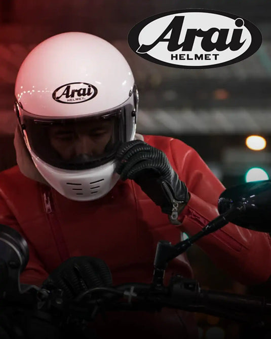 Un casco de motocicleta blanco de cara completa con una visera oscura y ranuras de ventilación en la barra del mentón.