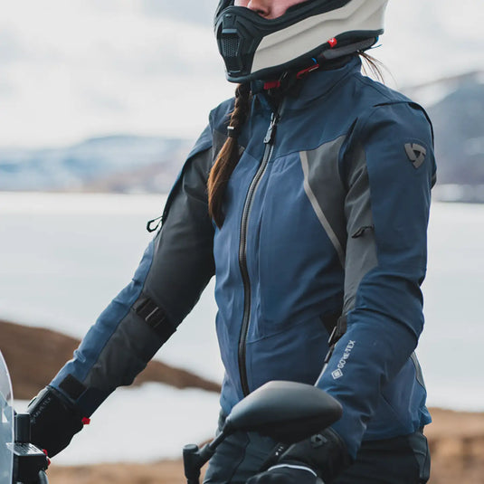 Chaqueta de motocicleta impermeable azul y gris con un logo sutil en el hombro.