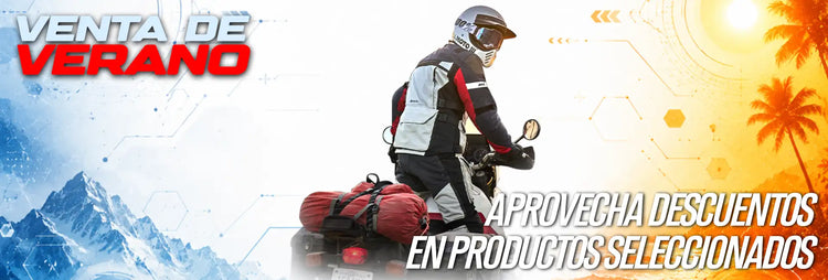 Motociclista con equipo negro y gris con detalles rojos conduciendo una motocicleta cargada con bolsas rojas contra un fondo dividido de montañas nevadas y palmeras tropicales.
