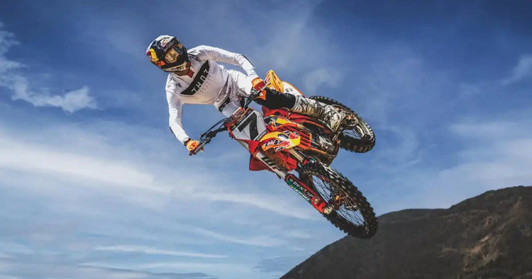 Piloto de motocross en el aire sobre una motocicleta de tierra
