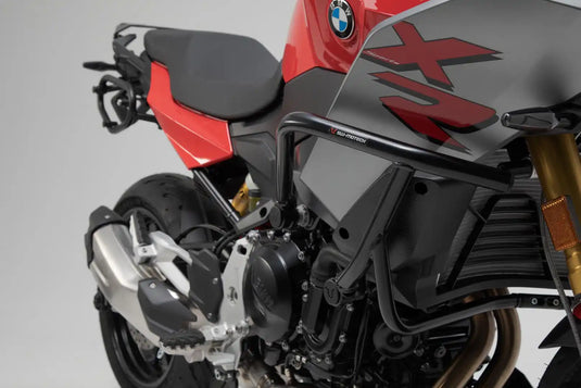 Motocicleta de aventura roja y negra con defensas y portaequipajes.